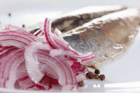 Salted herring on the plate with red onion, closeupの写真素材