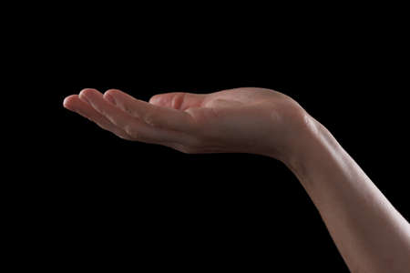 Gesture beautiful hand of a young girl, palm open up. Isolated on black background