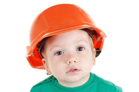 Little child plays with orange construction protective helmet  on white background. Profession future builder.の写真素材