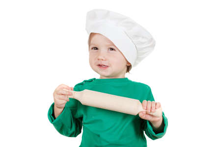 laughable little cook boy kneading the dough for the cookies, isolated on white background.  Half-length portrait of the table in studioの写真素材