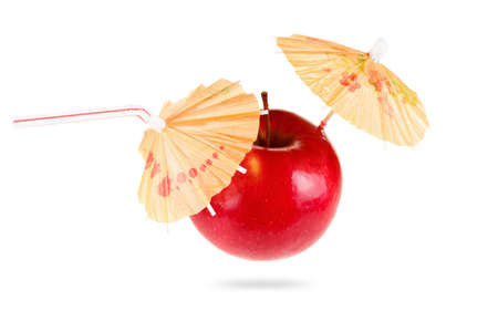 Concept of fresh apple juice featuring an apple with a straw and umbrella  in hand isolated on white background.の写真素材