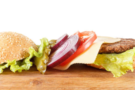Ingredients traditional American cheeseburger. Meat, bun and vegetables close up on white backgroundの写真素材