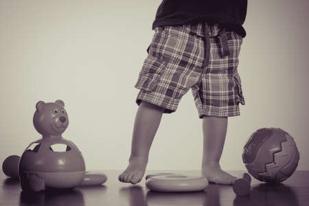 Caucasian baby playing with a toy pyramid. Photo in vintage style of old picturesの写真素材