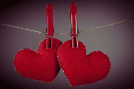 Red hearts hung from clothespins on rope. Concept of love or dating. vintage style.の写真素材