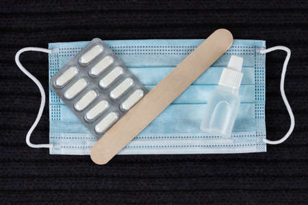 Medicine concept - pill, spatula, tablet and mask on the scarf closeup