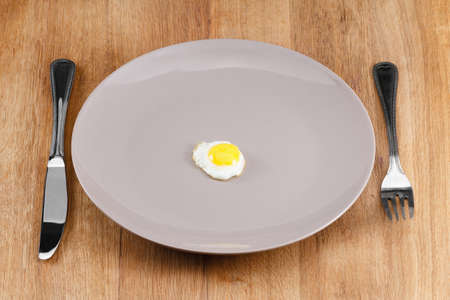 Small fried egg on a plate. Concept diet.の写真素材