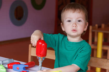 kid child boy playing with toys tools in kindergartenの写真素材