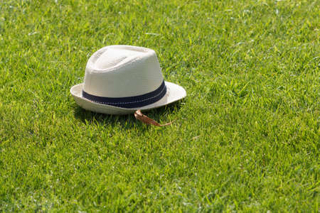 Hat on grass lawn. Summer background with green field.の写真素材