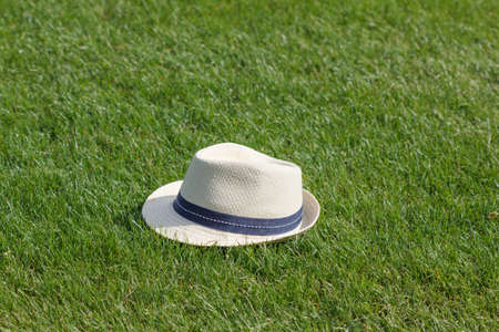 Hat on grass lawn. Summer background with green field.の写真素材