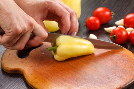 Cutting bell pepper on a board chef cookingの写真素材