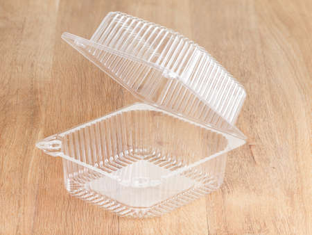 Empty transparent plastic storage box of food package on wooden background