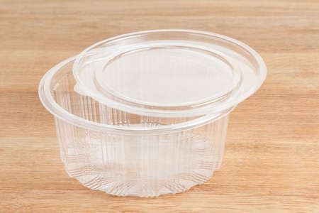 Empty round transparent plastic storage box of food package on wooden background