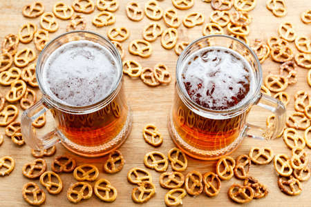 Mug of cold foamy beer with brezel. Overhead view. Traditional german Oktoberfest snacks and beer on wooden backgroundの写真素材