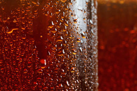 Beer background, macro flowing drops on the glass with bubbles, brown ale.の写真素材