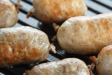 Chicken and beef sausages with brown grill marks in a grill pan closeupの写真素材