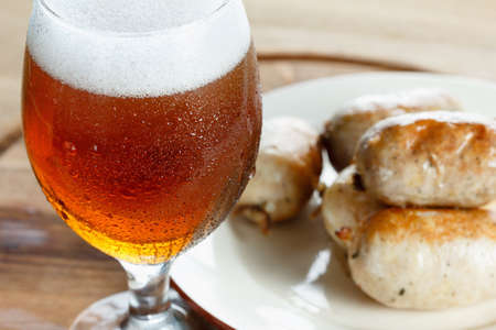 Traditional homemade coiled sausage with beer on wooden table