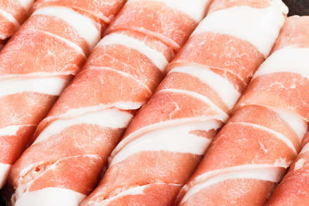 Slices of bacon roll closeup background, cooking foodの写真素材