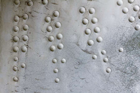 Old aluminum background detail of a military aircraft, surface corrosion. Oxidized metal texture with rivets.の写真素材