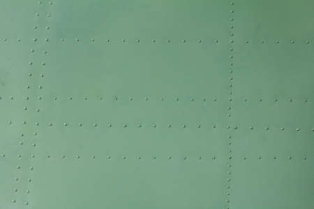 Old painted metal background detail of a military aircraft, surface corrosion, metal texture with rivets.の写真素材
