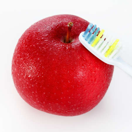 apple with a toothbrush, on white. healthy dental care conceptsの写真素材