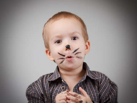 Child boy kid with cat makeup. Game and drawing. Humor and fun, happy childhood.の写真素材
