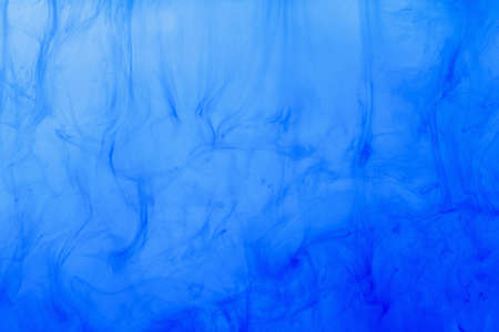 Blue smoke abstract background. Color ink drop splash wave in water. Cloud of paint.の写真素材