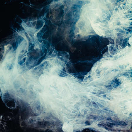 Abstract pattern of Billowing white smoke on a black background. Waves of mist and clouds.の写真素材