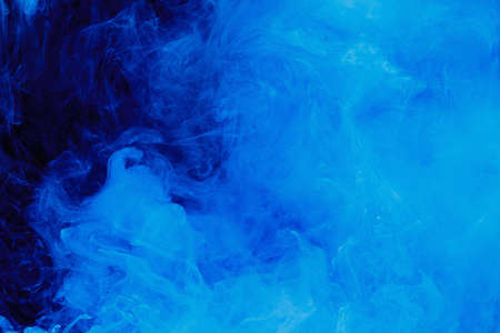 Abstract blue cloud pattern of white smoke on a black background. Waves of mist.の写真素材