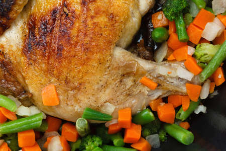 Whole grilled chicken with vegetables, cooked in a frying panの写真素材