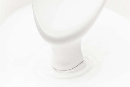 spoon in white sour cream or yogurt close-upの写真素材