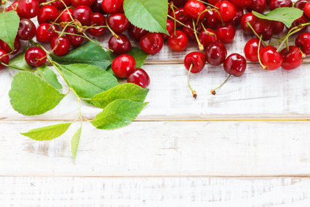 Ripe cherries on wooden table. View from above with copy space