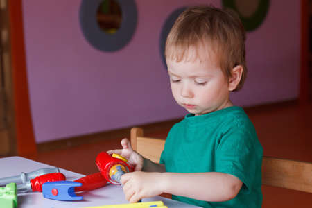 Little boy, the child plays with blocks and toys at the tableの写真素材