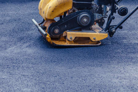 Road compactor makes a new sidewalk. Road roller working on the new road construction siteの写真素材