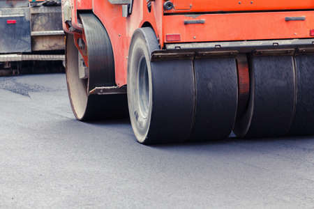 Road roller working on the new road construction site. Roadwork with heavy machinery.の写真素材