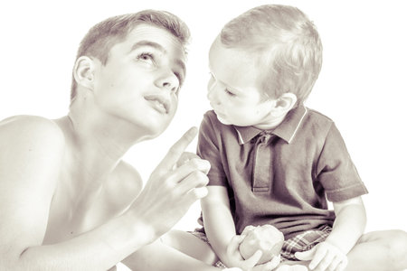 Brothers playing with apple and eating on white background.の写真素材
