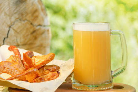 Octoberfest mug beer with traditional food on nature background.の写真素材