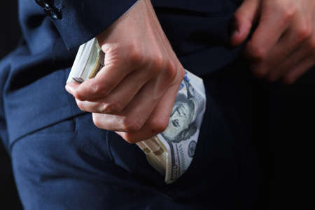 Concept for corruption, bankruptcy, bail, crime, bribing, fraud, auction bidding Bundle of dollar cash in handの写真素材