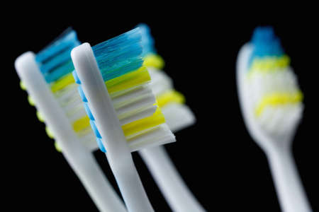 Set of colorful toothbrushes over black closeupの写真素材