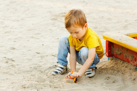 Child boy playing on playground summer cheerful activity.の写真素材