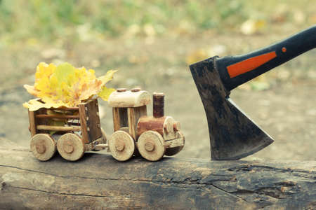 Colorful foliage background and a toy train. Fall October or November. Brightly colored maple leaves during autumn in park.の写真素材