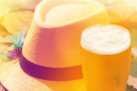 Beer glass pint octoberfest picnic on background with hat and autumn yellow leavesの写真素材