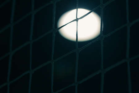 View through the net grid. Football field and lampの写真素材
