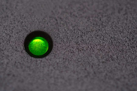 Macro green power LED on black plastic with copy spaceの写真素材