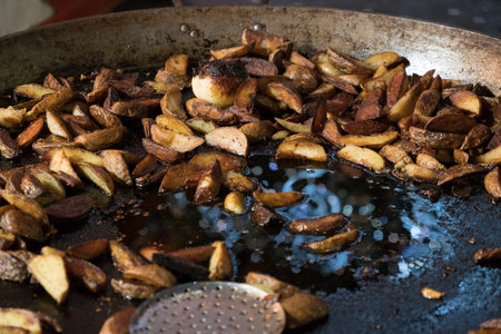 Fried potatoes on a huge frying pan, fast food. Street food Night Market.の写真素材