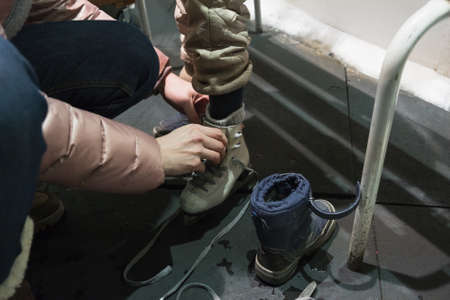 Mother and little child dress skates in the ice rink locker roomの写真素材