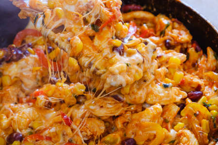 Pan with roasted vegetables, chicken and melted cheese for burritos close-up of cooking burrito food for dinner.の写真素材