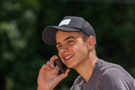 Happy teen boy on the street and using a smart phone