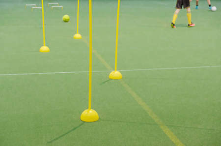 Soccer camp for kids. Children playeers training in motion soccer skills with balls and cones. Soccer slalom drills to improve football dribbling fastの写真素材