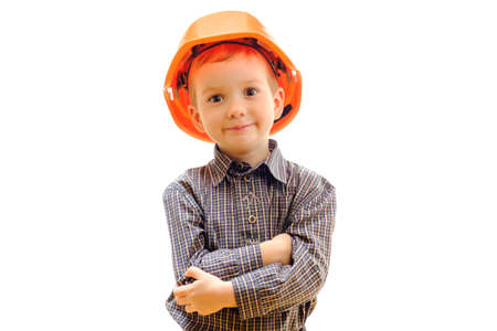Concept, small smiling boy child with construction helmet, looks afar isolated on white background copy spaceの写真素材