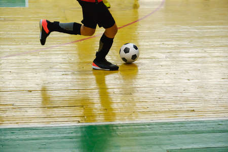 Children teen training soccer futsal indoor gym. Young boy with soccer ball training indoor football. Little player on playgroundの写真素材